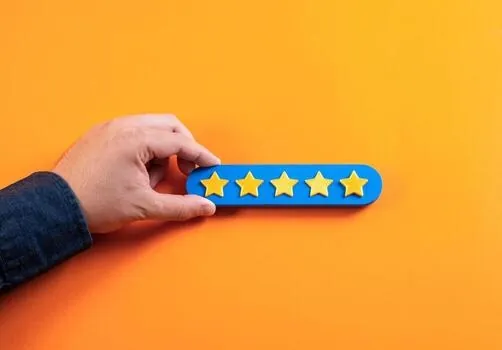 A hand placing a five-star review